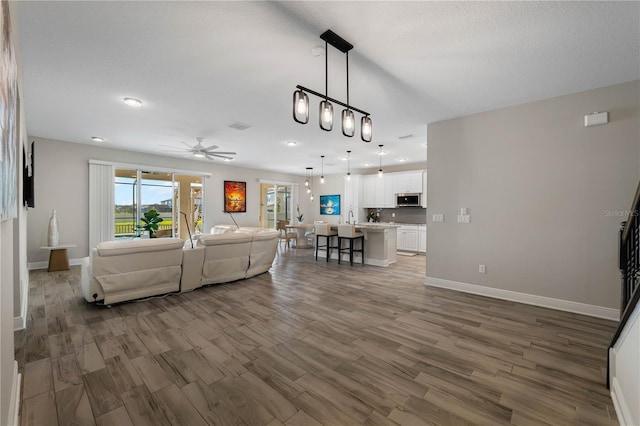 3091 King Fern Dr, Wimauma, FL 33598 - living area featuring wood finished floors, baseboards, recessed lighting, and a ceiling fan