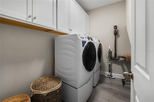 3091 King Fern Dr, Wimauma, FL 33598 - washroom with washer and clothes dryer, cabinet space, baseboards, and light wood-type flooring