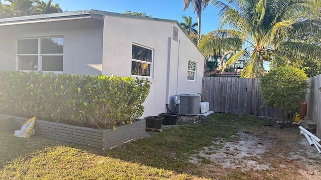 3225 Johnson St, Hollywood, FL 33021 - view of side of home featuring a fenced backyard, central AC unit, and stucco siding