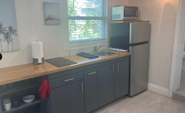 3225 Johnson St, Hollywood, FL 33021 - kitchen with appliances with stainless steel finishes, a sink, and baseboards