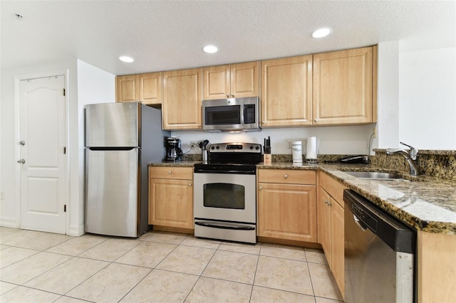 11605 Gulf Blvd Unit 506, Saint Petersburg, FL 33706 - kitchen featuring appliances with stainless steel finishes, light brown cabinetry, dark stone counters, light tile patterned flooring, and recessed lighting