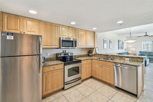 11605 Gulf Blvd Unit 506, Saint Petersburg, FL 33706 - kitchen with appliances with stainless steel finishes, a sink, open floor plan, a peninsula, and dark stone countertops