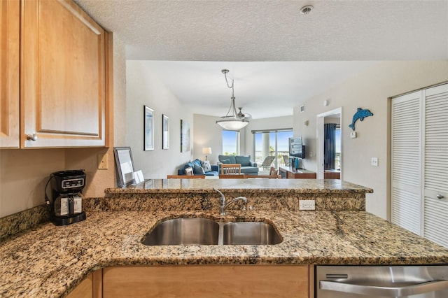 11605 Gulf Blvd Unit 506, Saint Petersburg, FL 33706 - kitchen with a sink, stainless steel dishwasher, stone counters, open floor plan, and hanging light fixtures