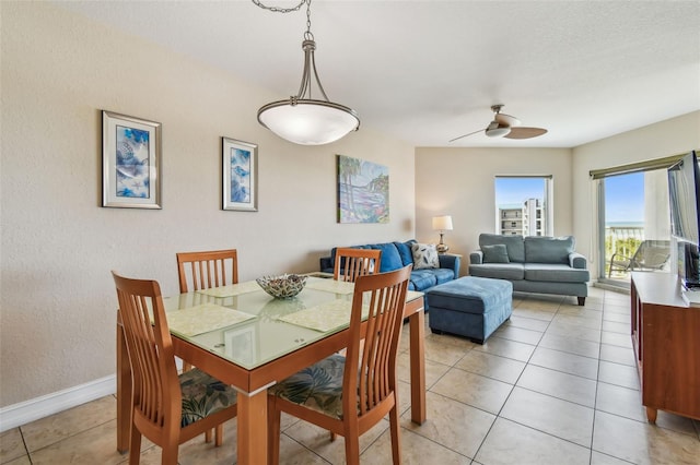 11605 Gulf Blvd Unit 506, Saint Petersburg, FL 33706 - dining room featuring light tile patterned floors, ceiling fan, baseboards, and a textured wall