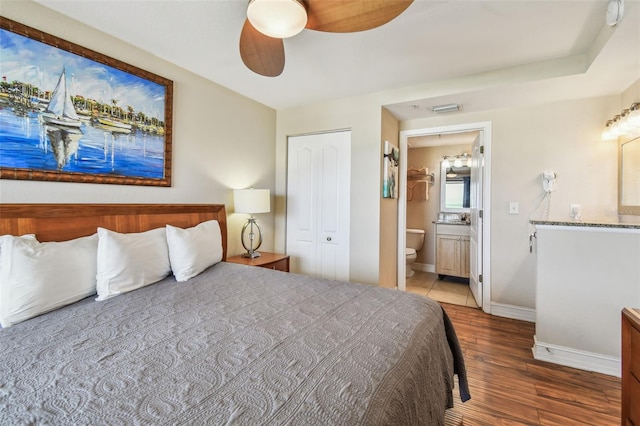 11605 Gulf Blvd Unit 506, Saint Petersburg, FL 33706 - bedroom with wood finished floors, ensuite bath, baseboards, and a ceiling fan