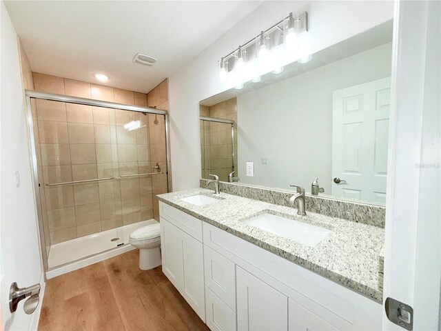 222 Carpenters Way Unit 71, Lakeland, FL 33805 - bathroom featuring wood finished floors, double vanity, a shower stall, and toilet