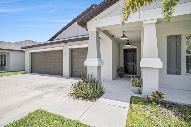 146 Rain Berry Ave, Ruskin, FL 33570 - view of exterior entry featuring driveway, a garage, and stucco siding