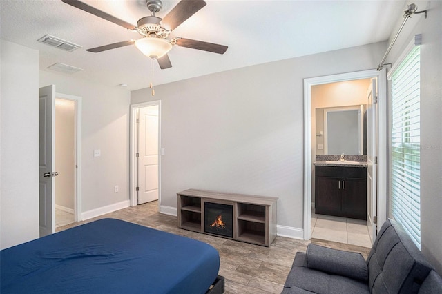 146 Rain Berry Ave, Ruskin, FL 33570 - bedroom featuring light wood-type flooring, ensuite bathroom, and a ceiling fan