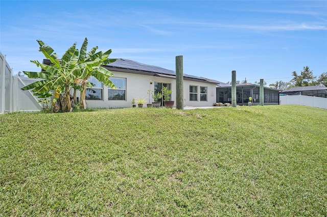 146 Rain Berry Ave, Ruskin, FL 33570 - back of house featuring solar panels, a fenced backyard, stucco siding, and a sunroom