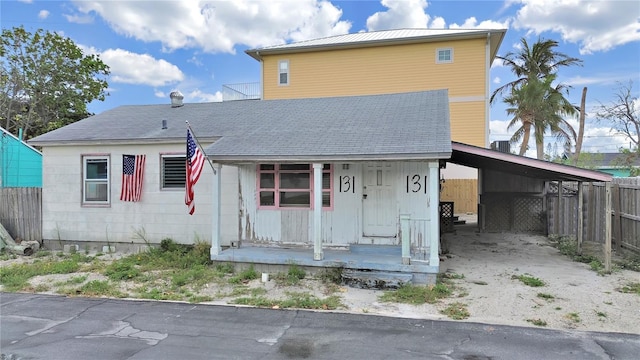 131 92nd Ave, Treasure Island, FL 33706 - back of property with covered porch, an attached carport, central AC unit, and driveway
