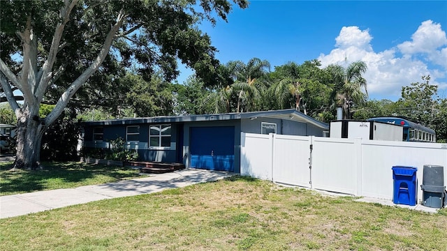 1631 St Mary Dr, Dunedin, FL 34698 - view of front of property with driveway, a garage, and view of wooded area