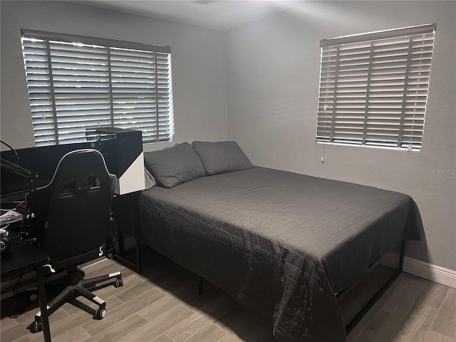 1631 St Mary Dr, Dunedin, FL 34698 - bedroom featuring light wood finished floors, baseboards, and an office area
