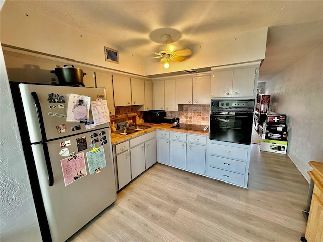 2434 Australia Way E Unit 38, Clearwater, FL 33763 - kitchen featuring black appliances, light wood-style flooring, backsplash, and a sink