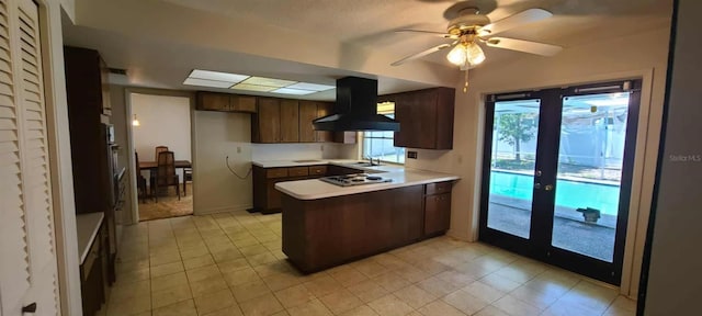 3717 Mckay Creek Dr, Largo, FL 33770 - kitchen with wall chimney exhaust hood, a peninsula, white cooktop, a sink, and light countertops