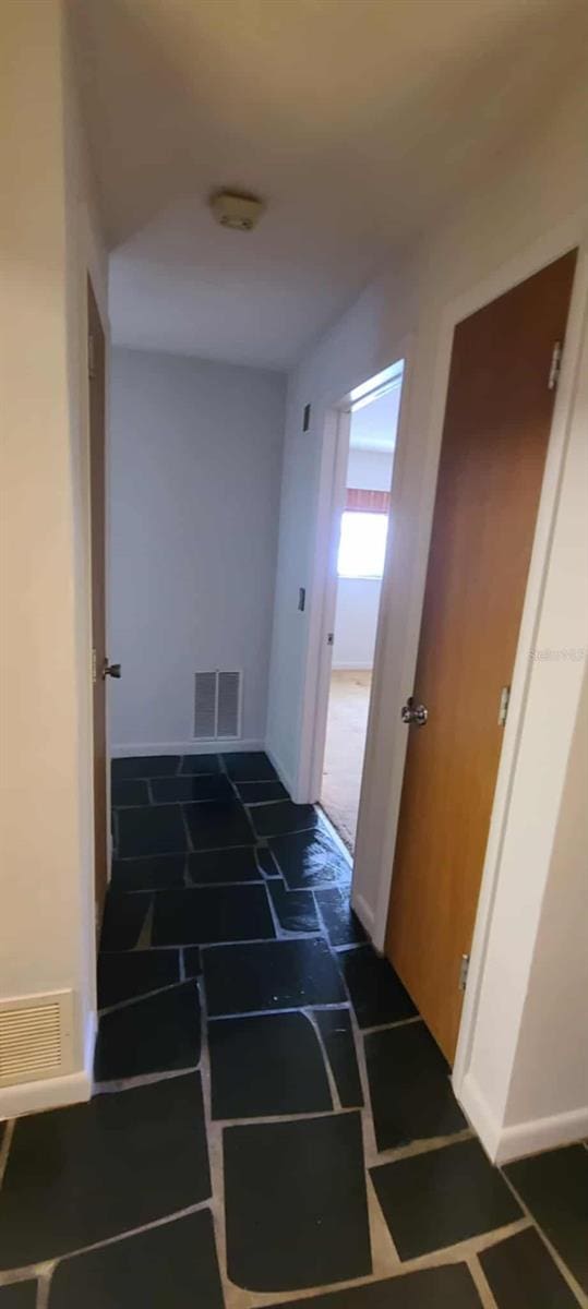 3717 Mckay Creek Dr, Largo, FL 33770 - corridor featuring dark stone finish floors