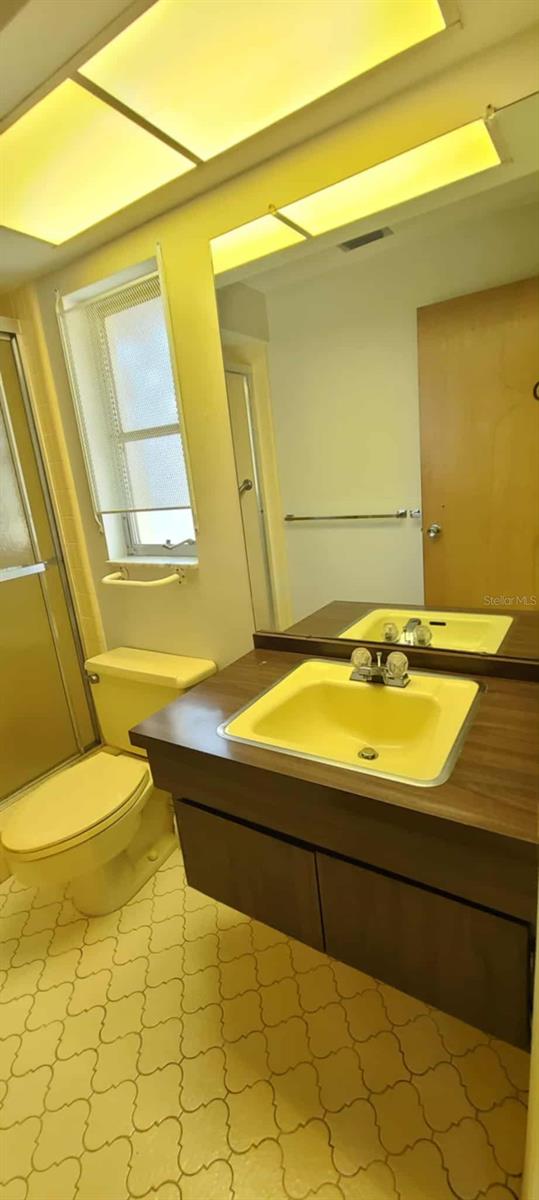 3717 Mckay Creek Dr, Largo, FL 33770 - full bathroom featuring vanity, toilet, and a stall shower