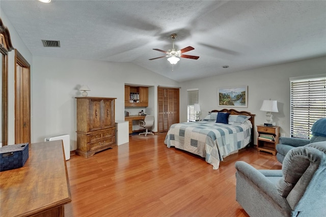 414 Summit Chase Dr, Valrico, FL 33594 - bedroom featuring a desk, light wood-style floors, lofted ceiling, a textured ceiling, and a ceiling fan