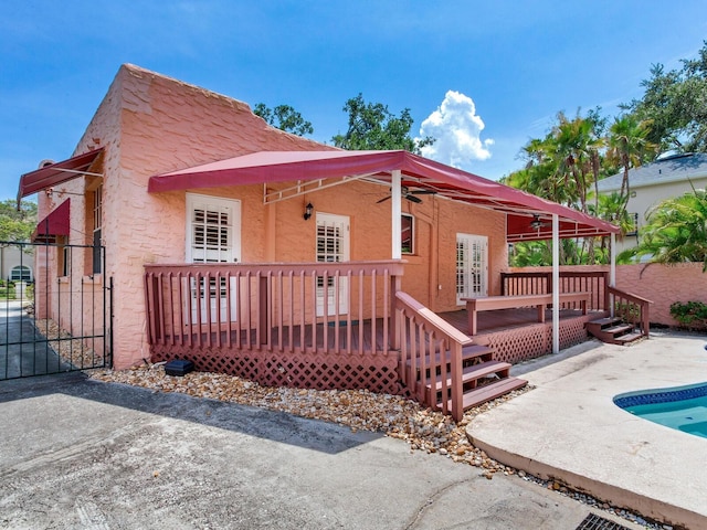 4521 W Azeele St, Tampa, FL 33609 - rear view of property with a deck, a swimming pool, stucco siding, a patio area, and a ceiling fan