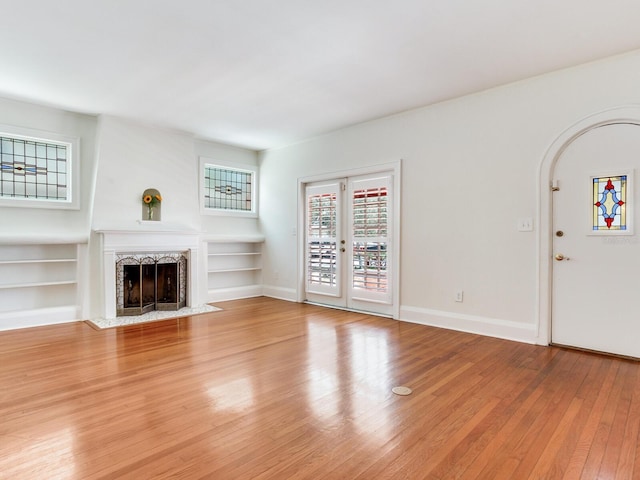 4521 W Azeele St, Tampa, FL 33609 - unfurnished living room with wood-type flooring, a fireplace with flush hearth, built in shelves, and baseboards