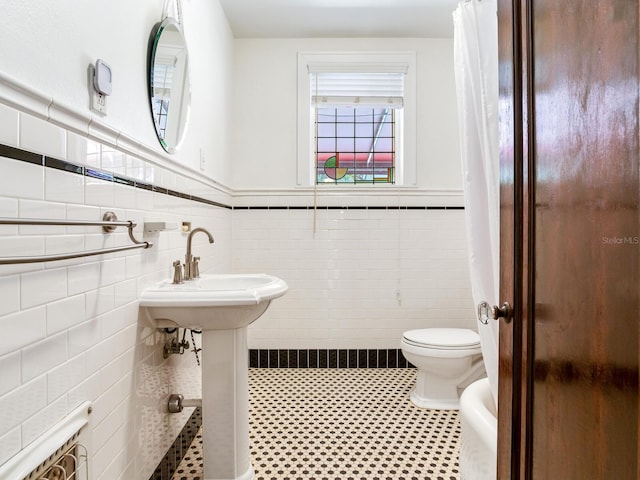 4521 W Azeele St, Tampa, FL 33609 - bathroom with toilet, a wainscoted wall, and tile walls