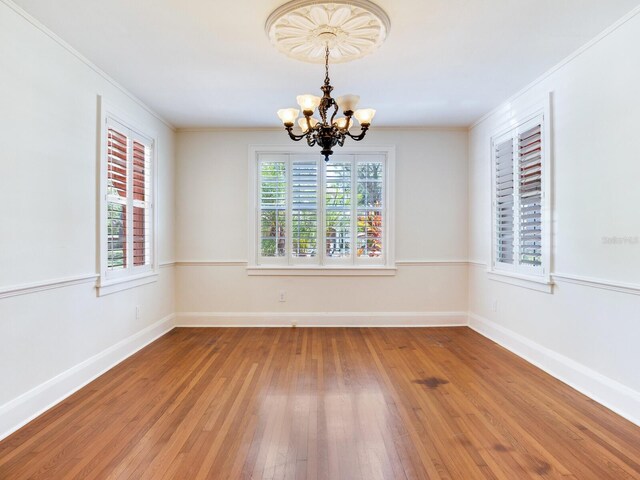 4521 W Azeele St, Tampa, FL 33609 - spare room with a chandelier, hardwood / wood-style floors, crown molding, and baseboards