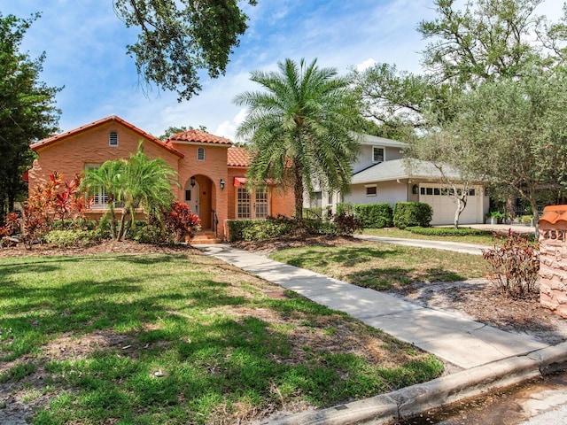 4521 W Azeele St, Tampa, FL 33609 - view of front of home with a tiled roof, a front lawn, stucco siding, and a garage