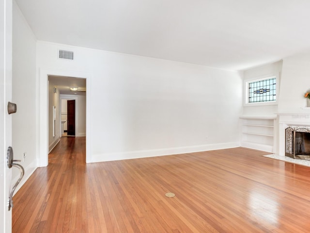 4521 W Azeele St, Tampa, FL 33609 - unfurnished living room featuring light wood-type flooring, a fireplace, and baseboards