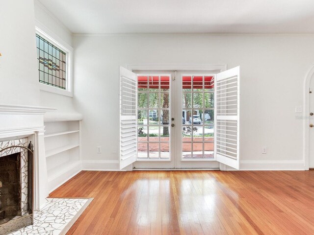 4521 W Azeele St, Tampa, FL 33609 - unfurnished living room with french doors, a fireplace with flush hearth, hardwood / wood-style flooring, baseboards, and built in features