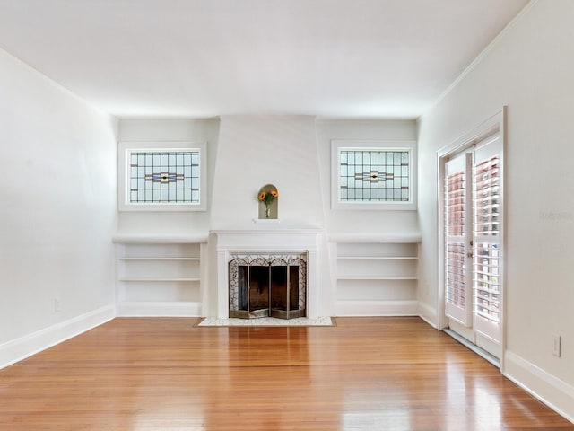 4521 W Azeele St, Tampa, FL 33609 - unfurnished living room with wood finished floors, built in shelves, a fireplace with flush hearth, and baseboards