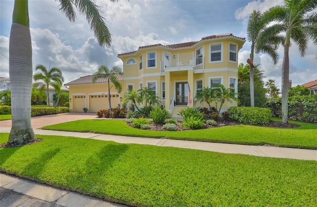 6468 Rubia Cir, Apollo Beach, FL 33572 - mediterranean / spanish-style house featuring french doors, a balcony, a front yard, a tile roof, and driveway