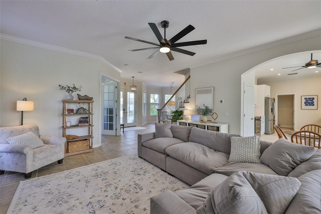 6468 Rubia Cir, Apollo Beach, FL 33572 - living room featuring a ceiling fan, light tile patterned floors, ornamental molding, stairs, and arched walkways