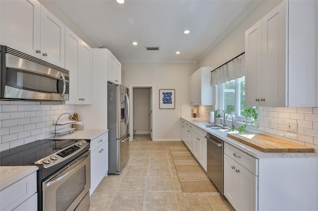 6468 Rubia Cir, Apollo Beach, FL 33572 - kitchen with appliances with stainless steel finishes, a sink, decorative backsplash, white cabinetry, and recessed lighting