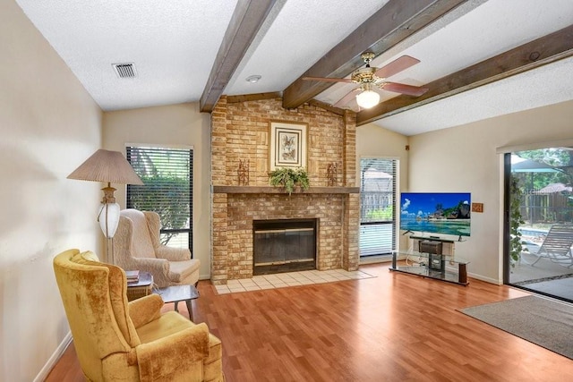 107 Halton Cir, Seffner, FL 33584 - living room with plenty of natural light, wood finished floors, a fireplace, a ceiling fan, and a textured ceiling