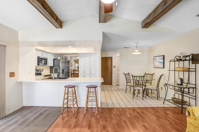 107 Halton Cir, Seffner, FL 33584 - kitchen featuring appliances with stainless steel finishes, a sink, a peninsula, white cabinets, and light countertops