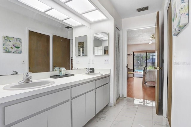 107 Halton Cir, Seffner, FL 33584 - bathroom featuring ensuite bath, double vanity, ceiling fan, marble look tile flooring, and a textured ceiling