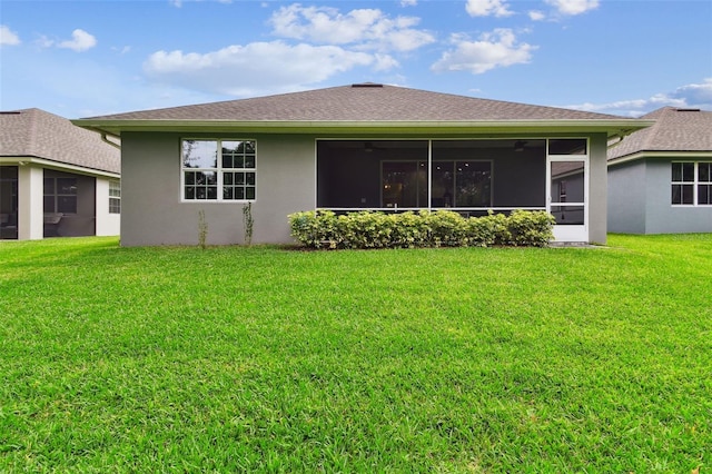 7991 Lake James Blvd, Lakeland, FL 33810 - back of property with a sunroom, a lawn, stucco siding, a ceiling fan, and roof with shingles