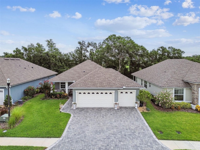 7991 Lake James Blvd, Lakeland, FL 33810 - ranch-style house featuring a front yard, decorative driveway, an attached garage, and stucco siding