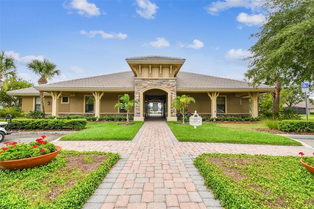 7991 Lake James Blvd, Lakeland, FL 33810 - view of front of house with stucco siding, a front yard, and a tile roof