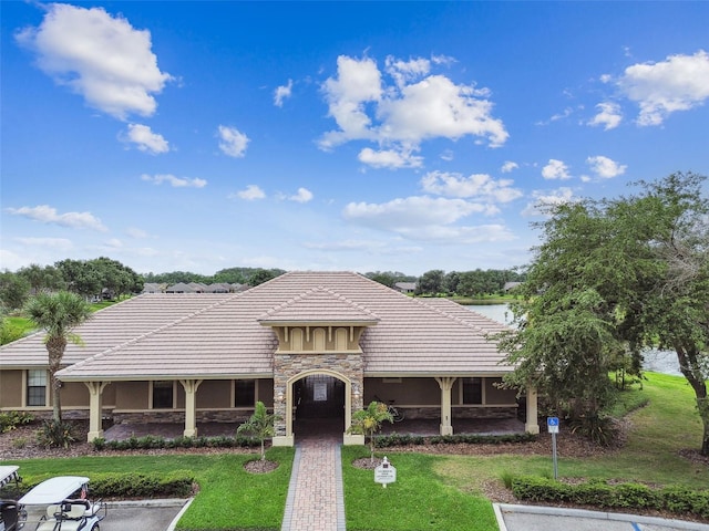 7991 Lake James Blvd, Lakeland, FL 33810 - view of front of house with stone siding, a front lawn, stucco siding, and a tiled roof