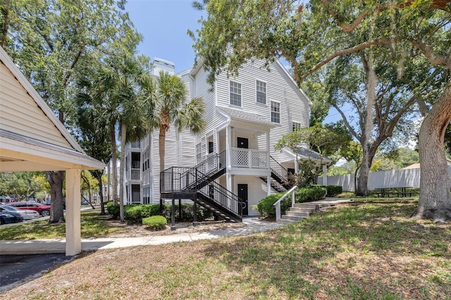 3301 Haviland Ct Unit 203, Palm Harbor, FL 34684 - rear view of property with stairs and a chimney