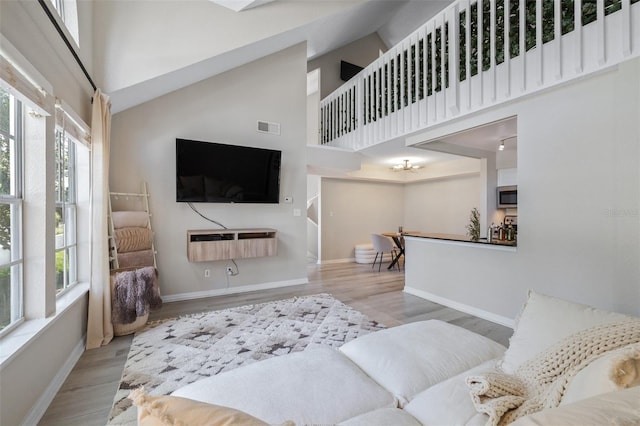 3301 Haviland Ct Unit 203, Palm Harbor, FL 34684 - living room with a towering ceiling, wood finished floors, and baseboards