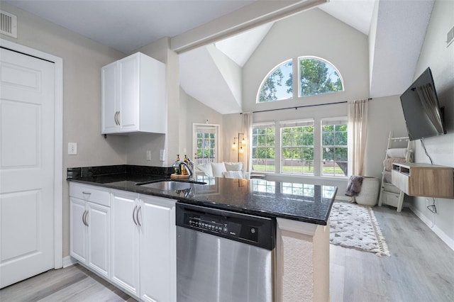 3301 Haviland Ct Unit 203, Palm Harbor, FL 34684 - kitchen with stainless steel dishwasher, open floor plan, light wood-style floors, a peninsula, and dark stone counters