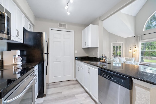 3301 Haviland Ct Unit 203, Palm Harbor, FL 34684 - kitchen featuring stainless steel appliances, a sink, white cabinets, light wood-type flooring, and dark stone countertops