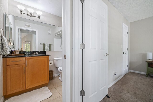 3301 Haviland Ct Unit 203, Palm Harbor, FL 34684 - bathroom with vanity, toilet, a textured ceiling, baseboards, and tile patterned floors