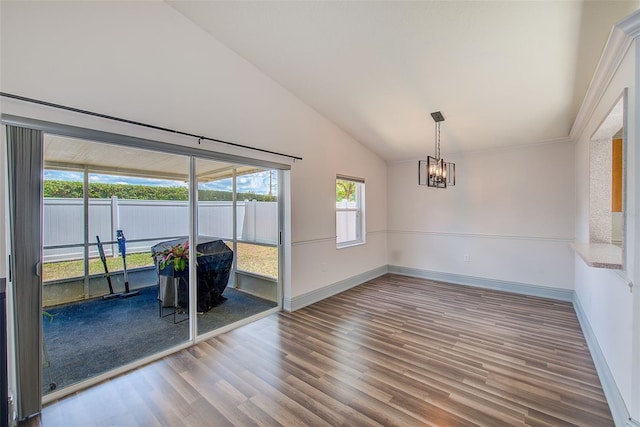 22943 Sills Loop, Land O Lakes, FL 34639 - unfurnished room with a chandelier, wood finished floors, vaulted ceiling, and baseboards