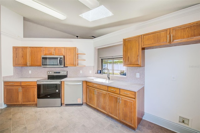 22943 Sills Loop, Land O Lakes, FL 34639 - kitchen with appliances with stainless steel finishes, a sink, backsplash, light countertops, and a skylight