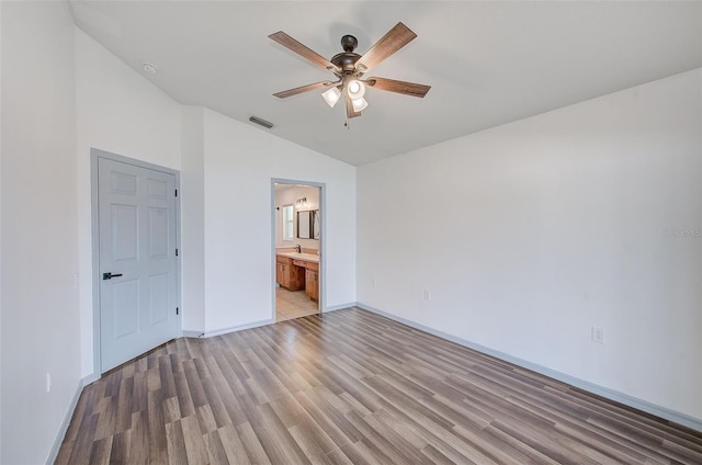 22943 Sills Loop, Land O Lakes, FL 34639 - unfurnished bedroom with lofted ceiling, light wood finished floors, baseboards, connected bathroom, and ceiling fan