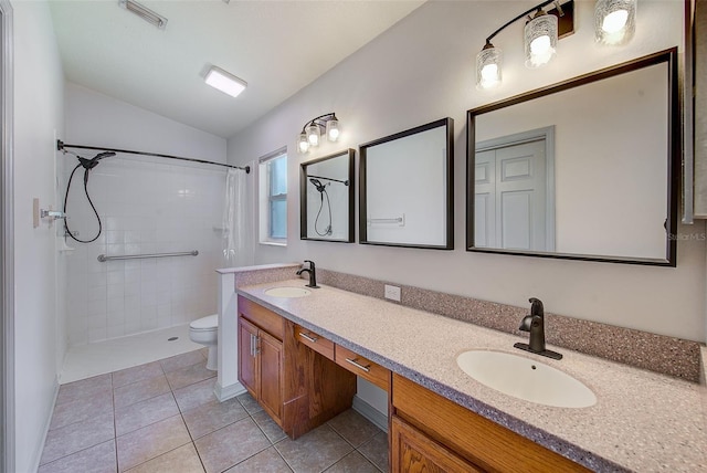 22943 Sills Loop, Land O Lakes, FL 34639 - bathroom featuring double vanity, toilet, a tile shower, lofted ceiling, and tile patterned flooring