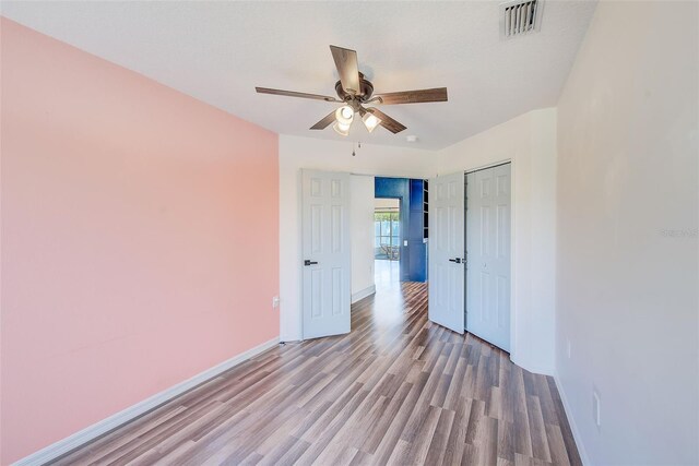 22943 Sills Loop, Land O Lakes, FL 34639 - spare room featuring a ceiling fan, wood finished floors, and baseboards