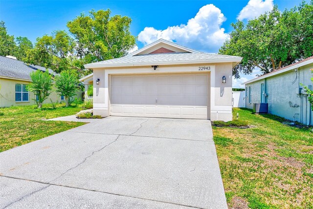22943 Sills Loop, Land O Lakes, FL 34639 - view of front facade with a garage, a front lawn, stucco siding, and concrete driveway